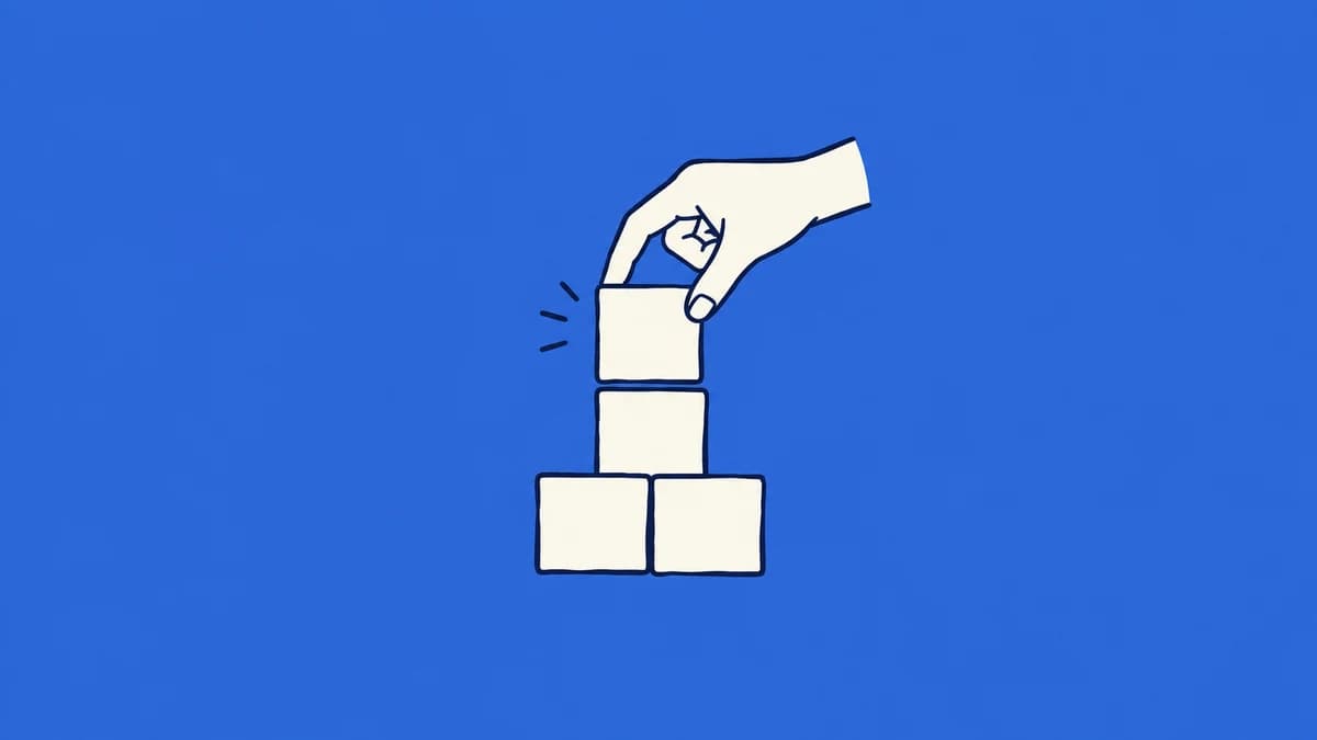 A hand fitting a block onto a stable foundation of blocks.